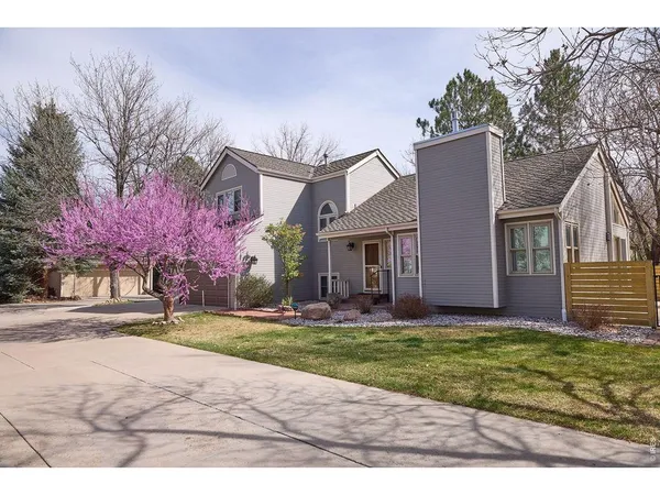a front view of house with yard and trees in the background