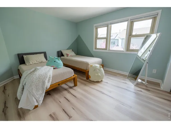 a bedroom with two beds and a wooden floor