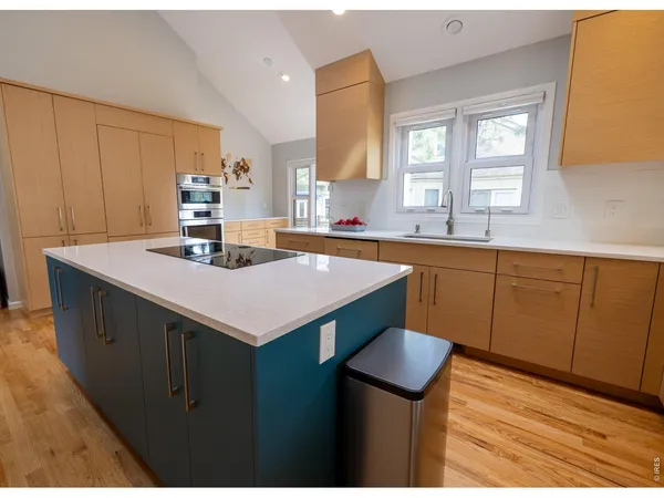a kitchen with a sink cabinets and wooden floor