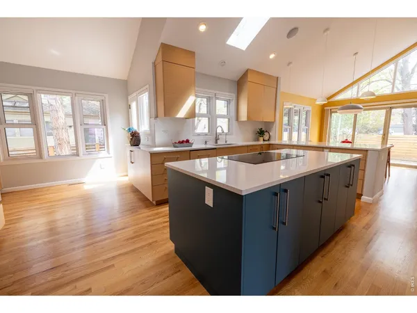 a kitchen with stainless steel appliances granite countertop a sink a stove a counter space and a window