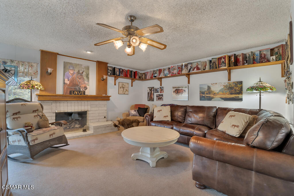 1278 Rambling Road Simi Valley, CA 93065 - Photo 12 of 76 a living room with furniture a chandelier and a fireplace
