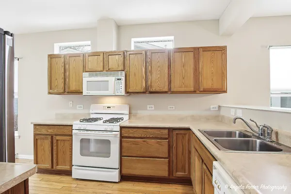 a kitchen with stainless steel appliances granite countertop a sink and cabinets with wooden floors