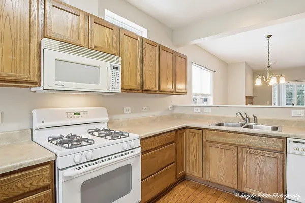 a kitchen with cabinets appliances a sink and a window