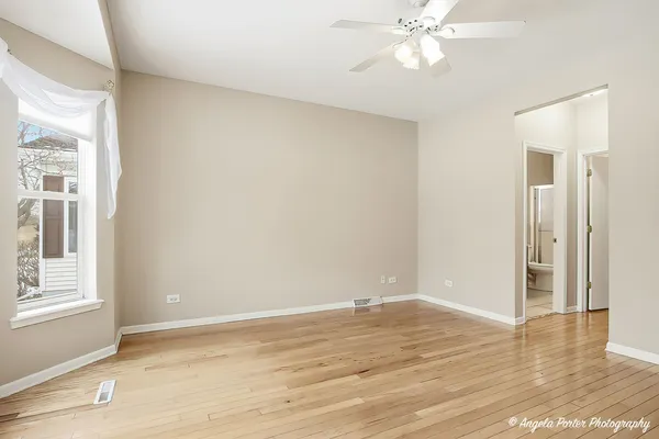 a view of a room with wooden floor and ceiling fan