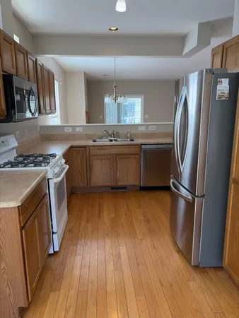 a kitchen with a sink a refrigerator and wooden floor