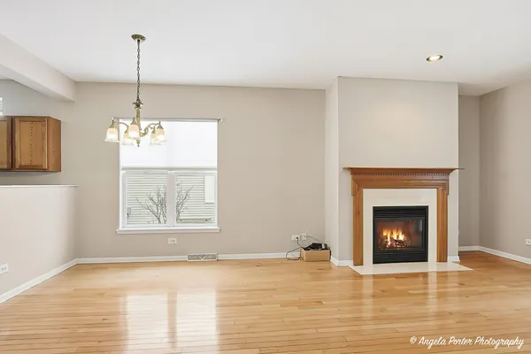 a view of an empty room with a fireplace and window