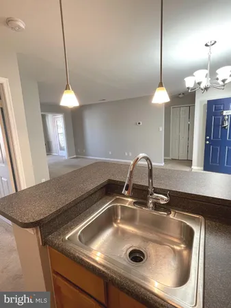 a kitchen with a sink a counter space and a chandelier
