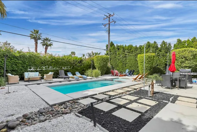 a view of a backyard with couches plants and wooden fence