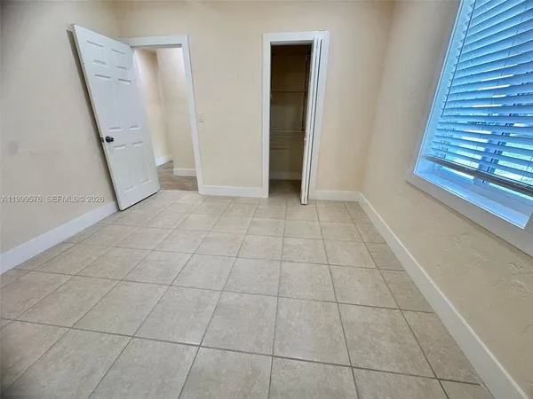 a view of a livingroom with an empty space and a window