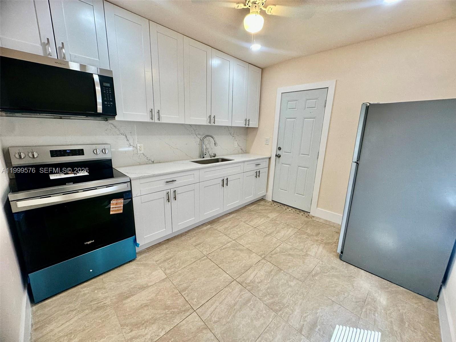 2014 Northwest 43rd Street Miami, FL 33142 - Photo 4 of 15 a kitchen with a sink and a stove top oven