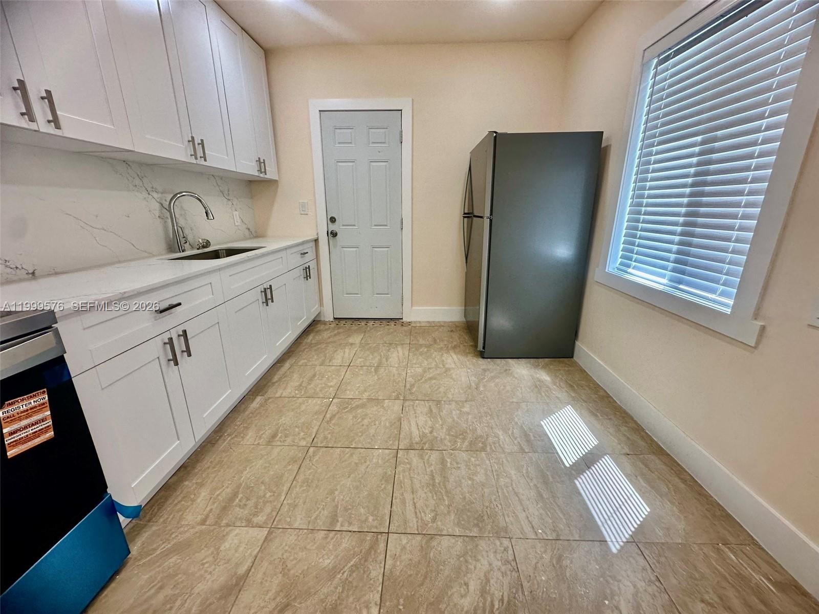 2014 Northwest 43rd Street Miami, FL 33142 - Photo 5 of 15 a kitchen with a refrigerator and cabinets