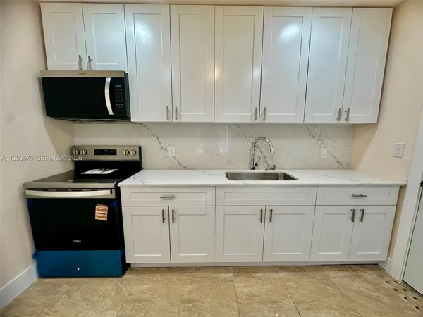 a kitchen with stainless steel appliances granite countertop a sink a stove and cabinets