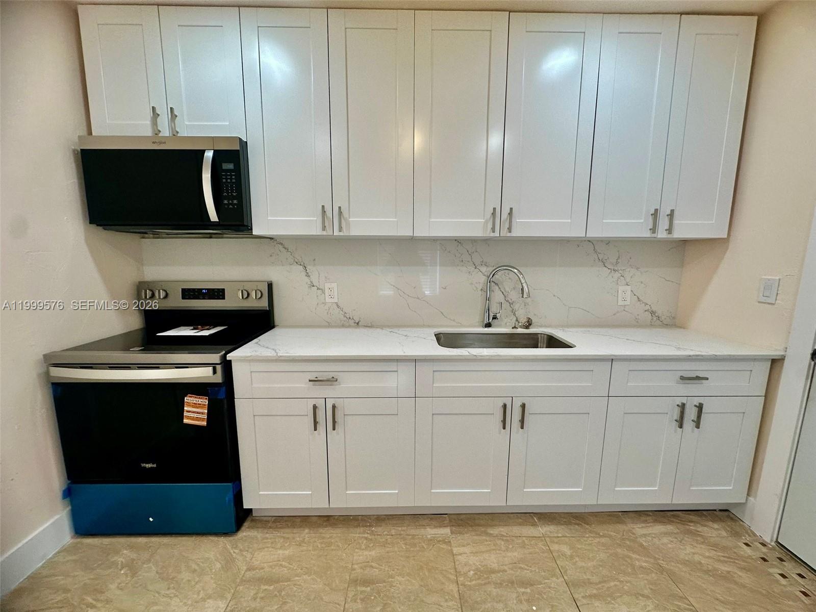 2014 Northwest 43rd Street Miami, FL 33142 - Photo 6 of 15 a kitchen with stainless steel appliances granite countertop a sink a stove and cabinets