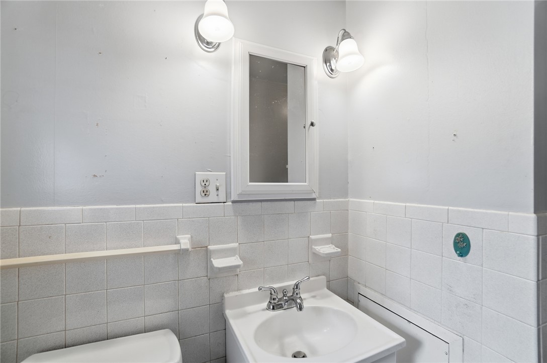 1087 Fairfield Road Troy, OH 45373 - Photo 20 of 39 This clean and bright bathroom features classic tiled walls and a functional sink area.