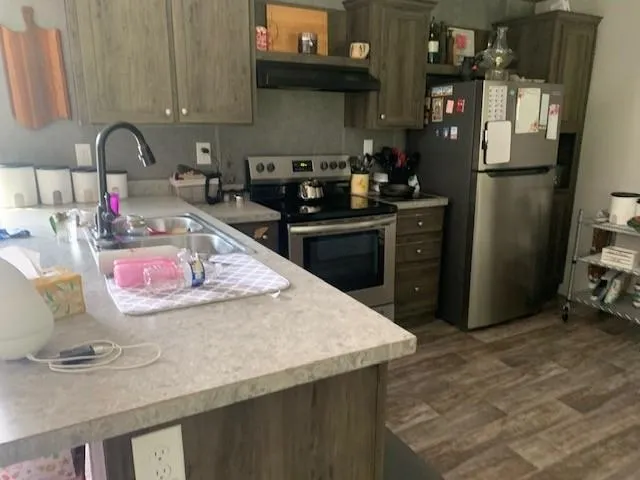 a kitchen with granite countertop a refrigerator a stove and a sink
