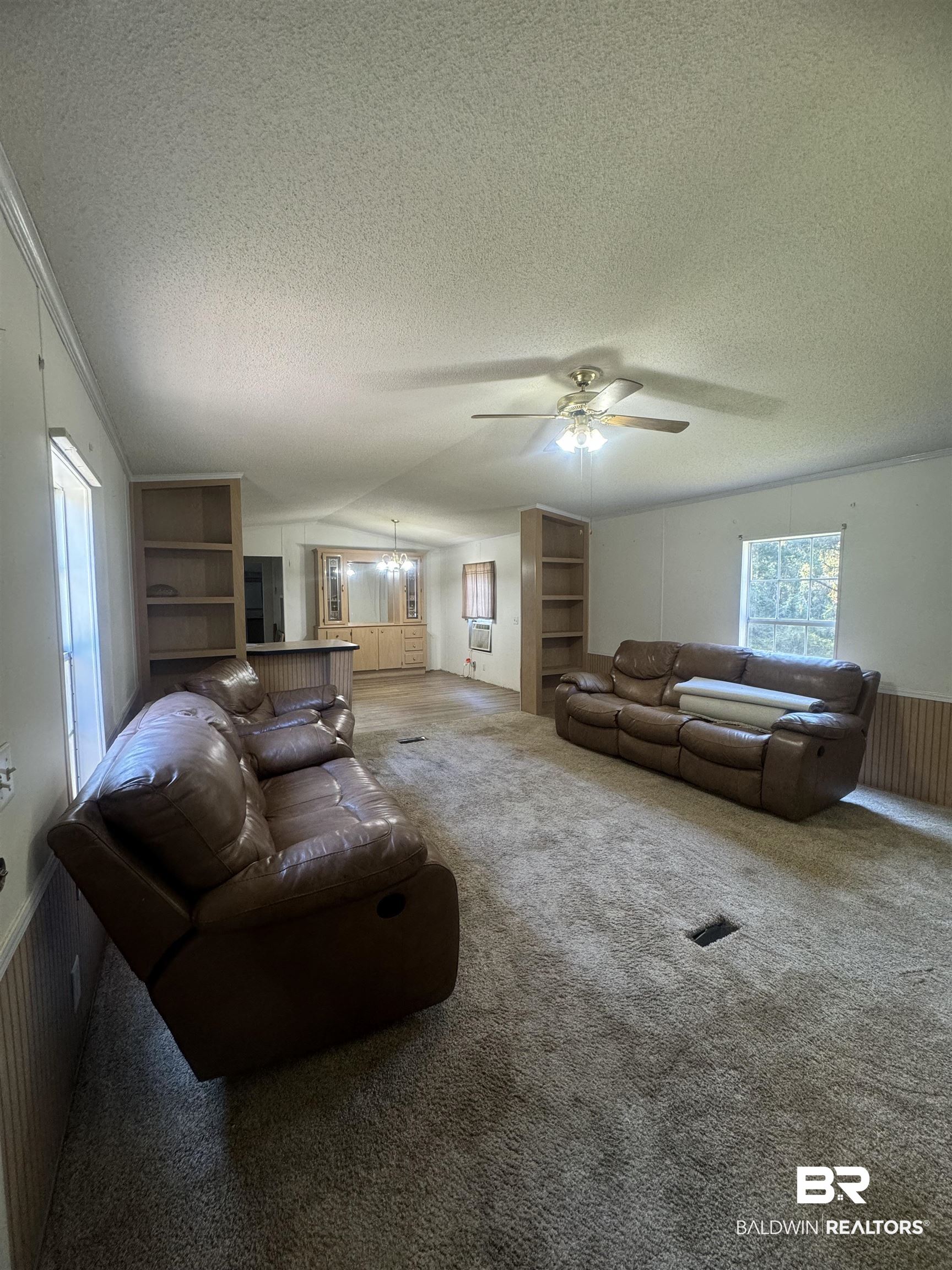 1067 County Road 7 Range, AL 36473 - Photo 30 of 30 Carpeted living room with wooden walls, a textured ceiling, and ceiling fan