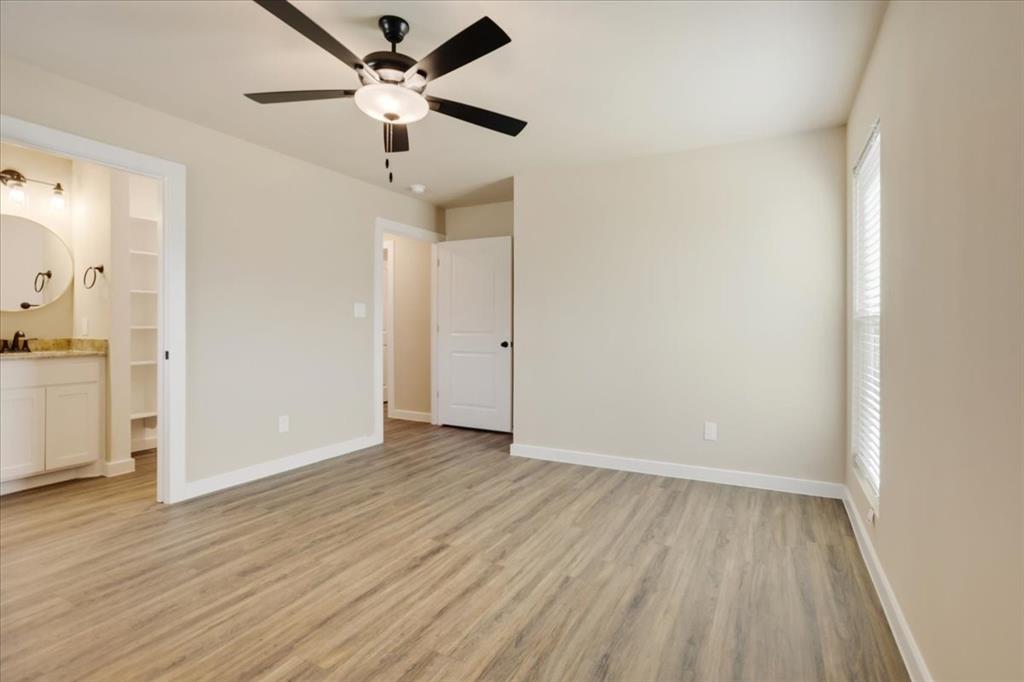 2385 Miller Street Denison, TX 75020 - Photo 14 of 26 an empty room with wooden floor and a ceiling fan