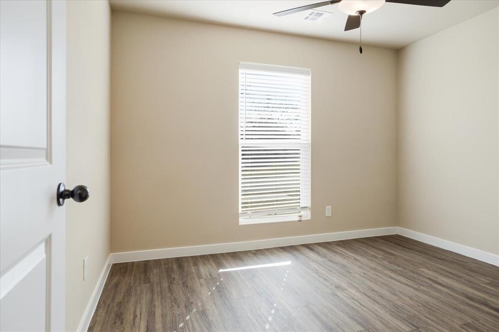 2385 Miller Street Denison, TX 75020 - Photo 20 of 26 a view of an empty room with a window and wooden floor