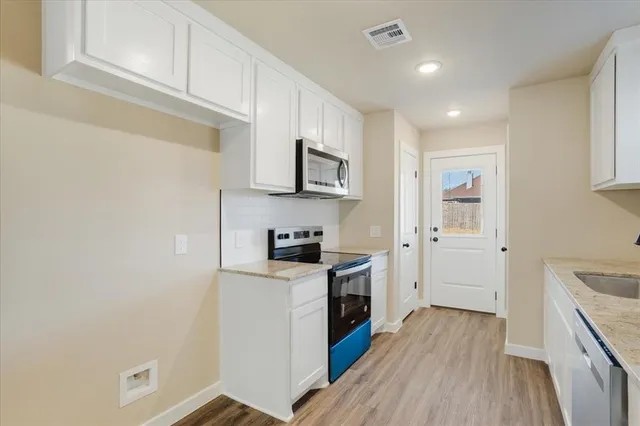 a kitchen with cabinets wooden floor and a sink