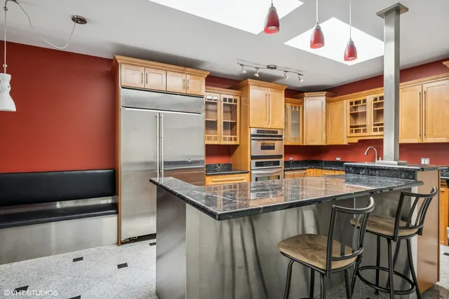 a kitchen with stainless steel appliances granite countertop a stove a sink and a refrigerator