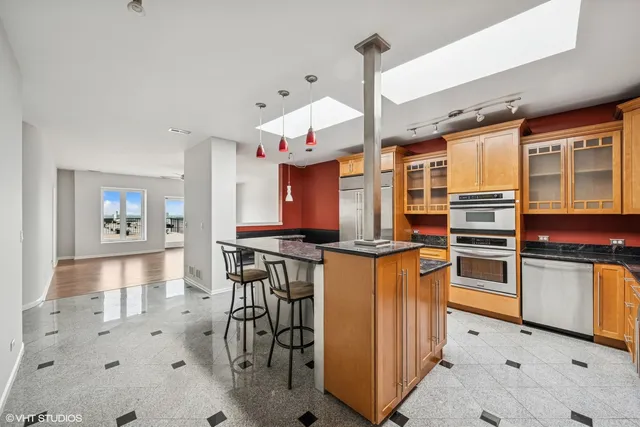 a kitchen with stainless steel appliances a stove a sink and a refrigerator