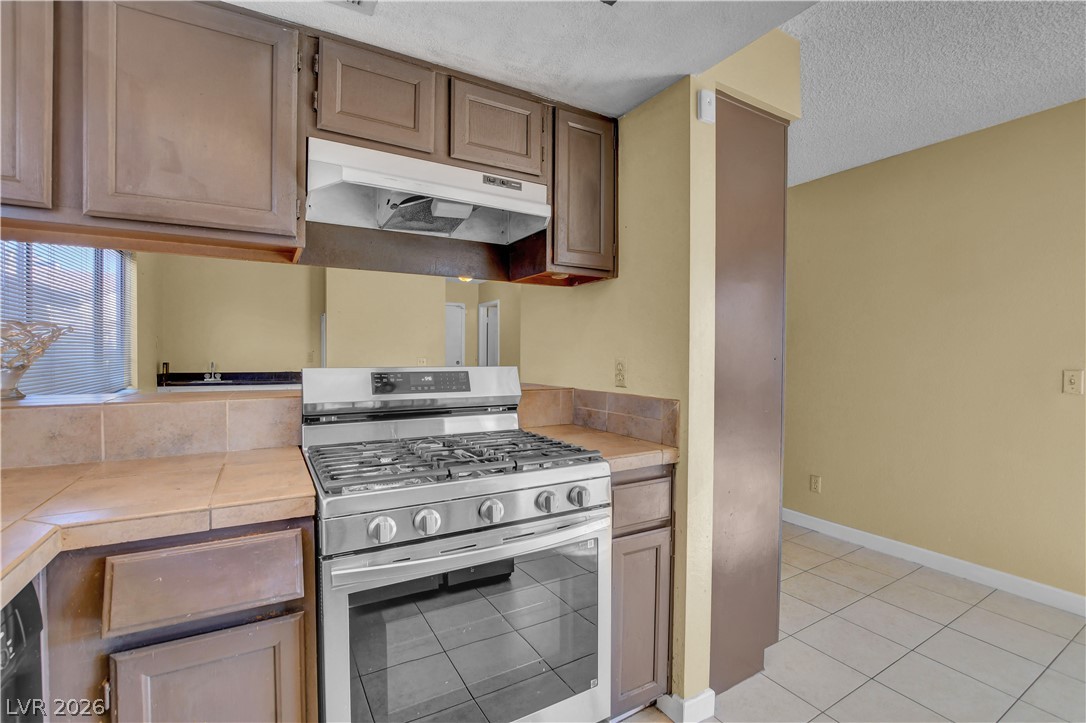 6440 Hartwood Road Las Vegas, NV 89108 - Photo 22 of 59 A well-appointed kitchen features a stainless steel gas range with a matching range hood.