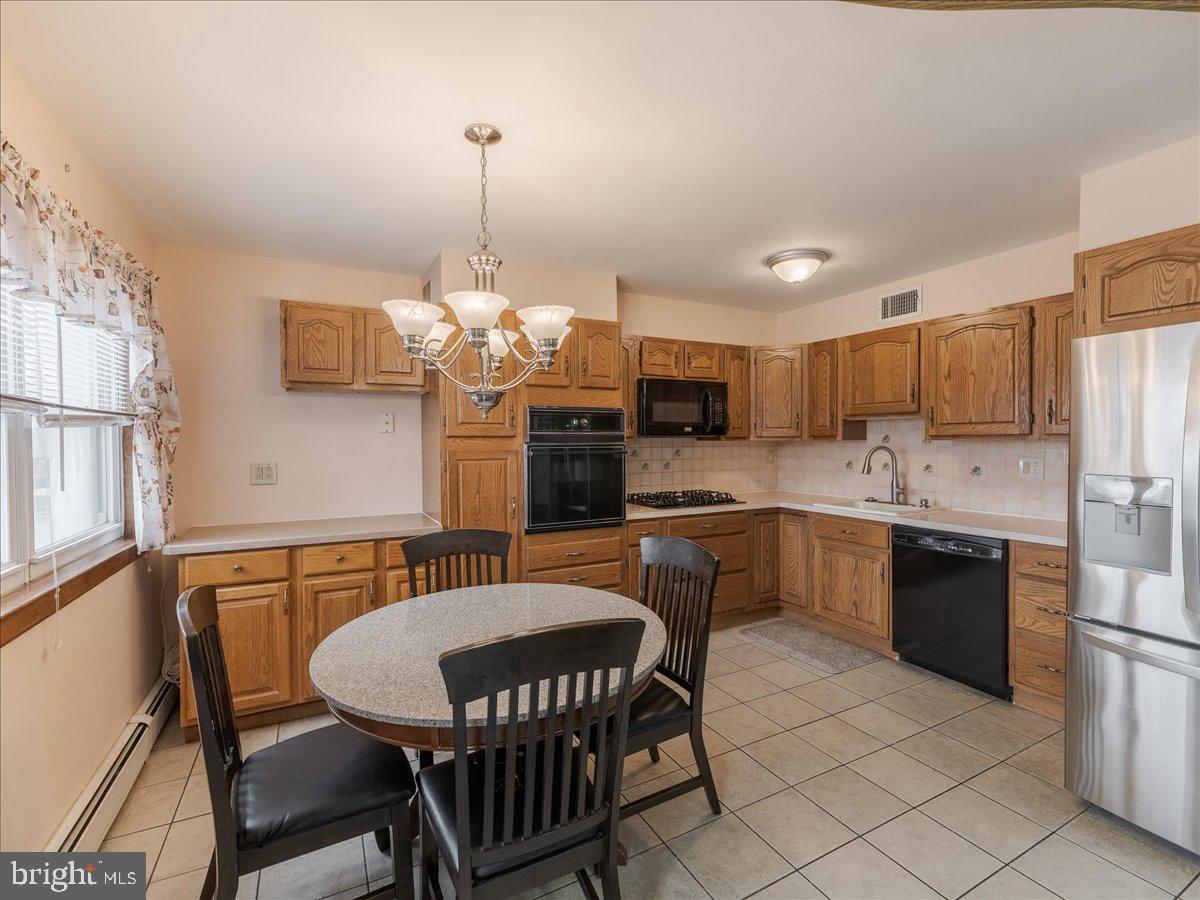 3249 Byberry Road Philadelphia, PA 19154 - Photo 9 of 28 a kitchen with stainless steel appliances granite countertop a kitchen island a table and chairs in it