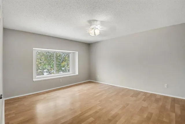 a view of an empty room with a chandelier fan