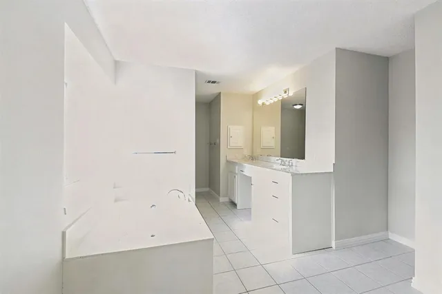 a bathroom with a tub a sink and mirror