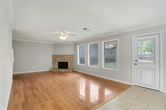 a view of an empty room with a fireplace and a window