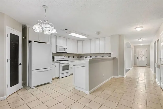 a kitchen with white cabinets sink and stainless steel appliances