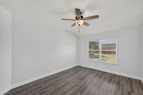 a view of a room with wooden floor and ceiling fan