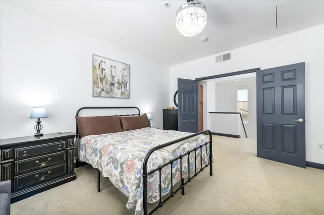 a bedroom with a bed and a chandelier