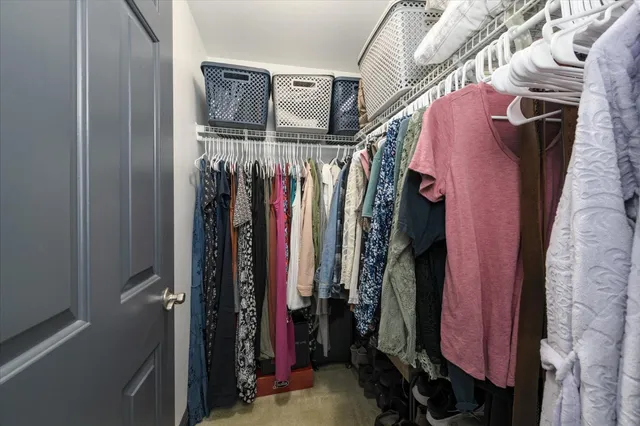 a view of walk in closet with clothes