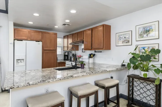a kitchen with granite countertop sink table and chairs