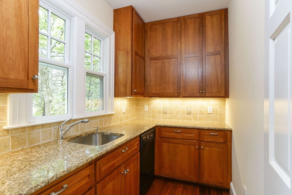 2 Hampton Road Lexington, MA 02421 - Photo 12 of 30 a kitchen with granite countertop wooden cabinets a sink and dishwasher next to a window