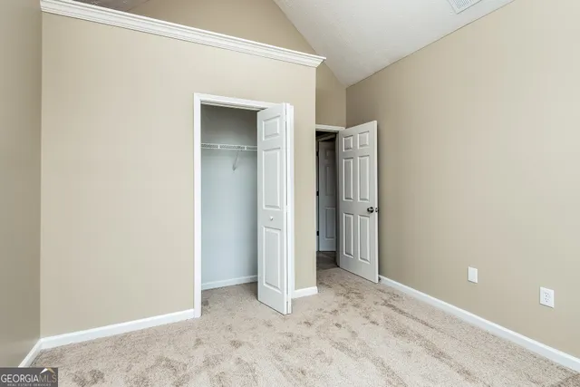 an empty room with closet and wooden floor