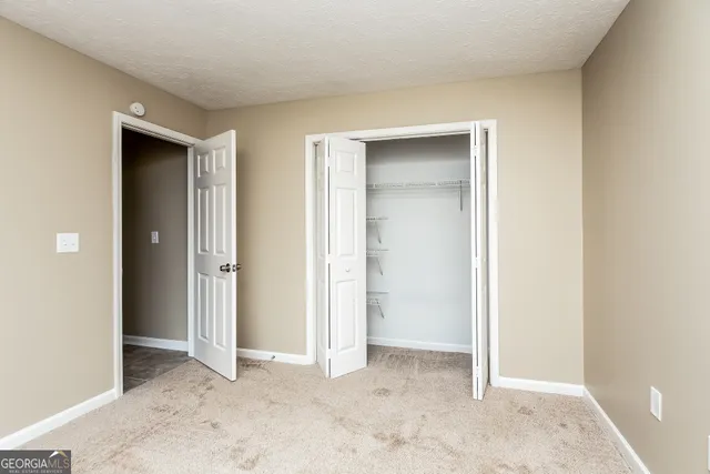 an empty room with closet and a bathroom