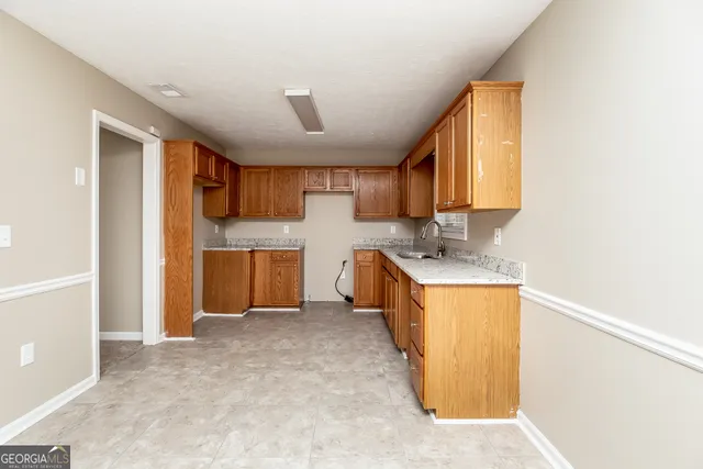 a kitchen with a refrigerator sink and cabinets