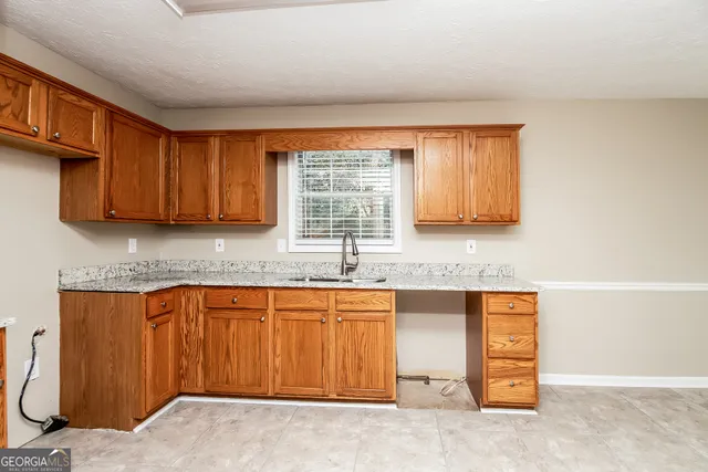 a kitchen with stainless steel appliances granite countertop a sink window and cabinets