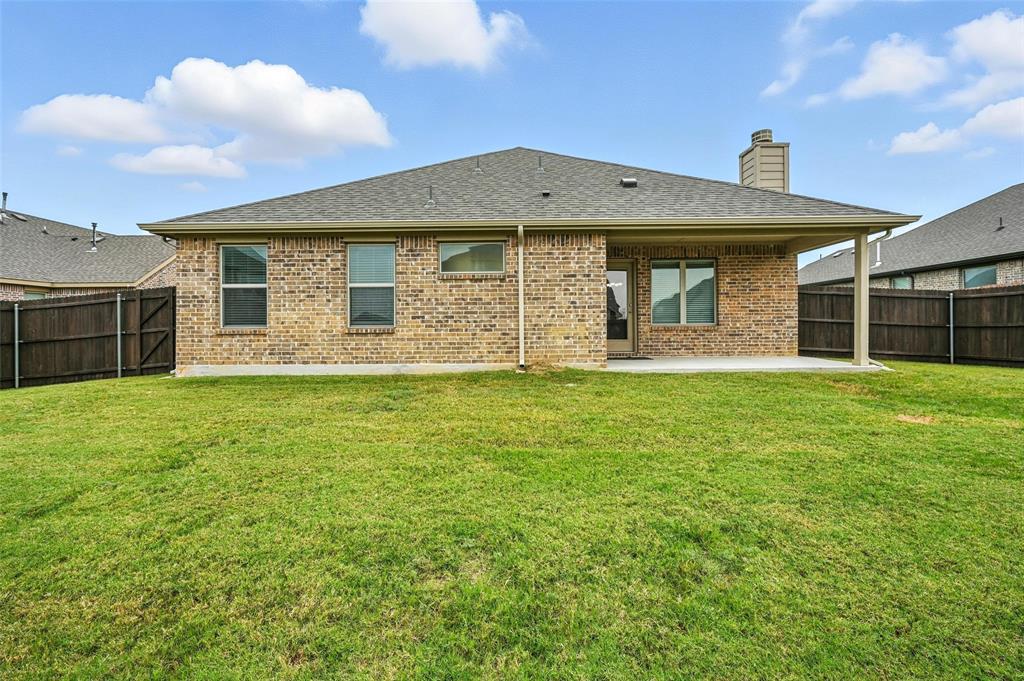 5 Pheasant Run Sanger, TX 76266 - Photo 26 of 27 Rear view of house with roof with shingles, a fenced backyard, a patio area, and brick siding