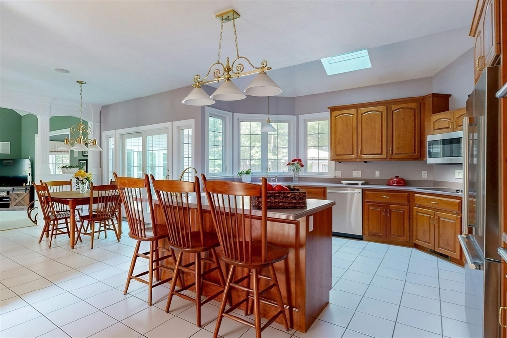 7 Riverbend Road Upton, MA 01568 - Photo 12 of 39 a kitchen with stainless steel appliances granite countertop a sink a stove a dining table and chairs