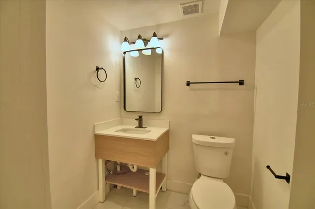 a bathroom with a toilet a sink and mirror