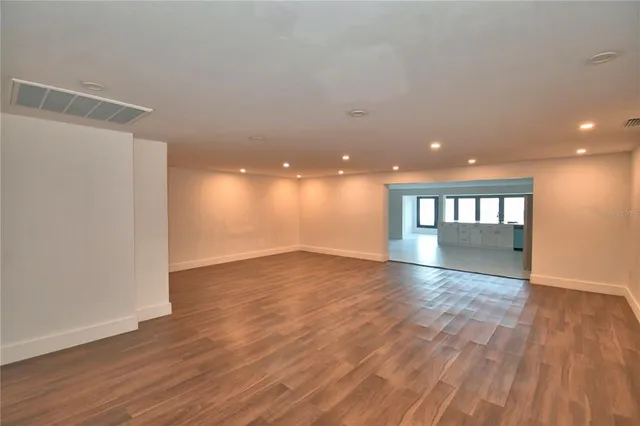 a view of empty room with wooden floor