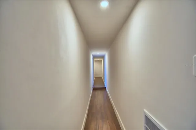 a view of a hallway with wooden floor