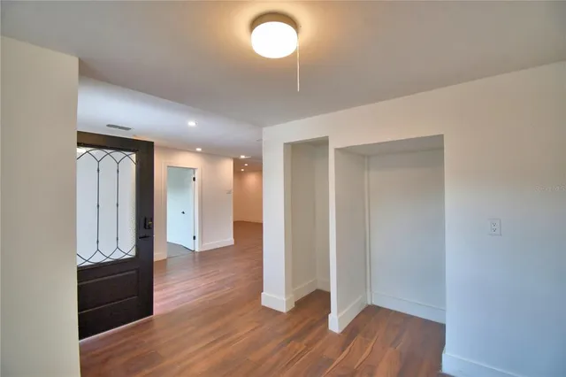 a view of empty room with wooden floor