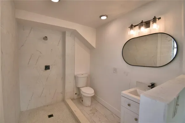 a bathroom with a sink a toilet and shower