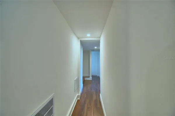 a view of a hallway with wooden floor