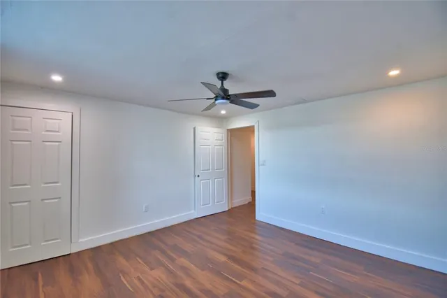a view of room with wooden floor and ceiling fan