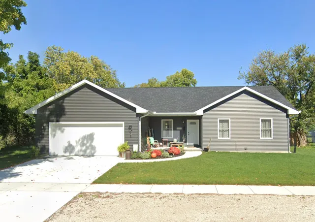 a front view of a house with a yard and trees